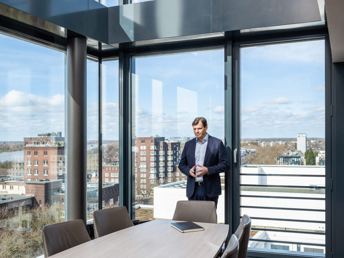 Businessfoto: Geschäftsmann im modernen Konferenzraum mit Panoramablick über die Stadt, seriöse und professionelle Atmosphäre