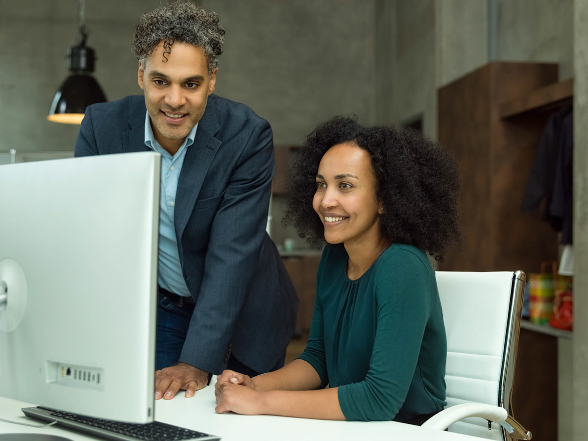 Professionelle Unternehmensfoto aus München: Zwei Kollegen arbeiten zusammen an einem Computer im Büro.