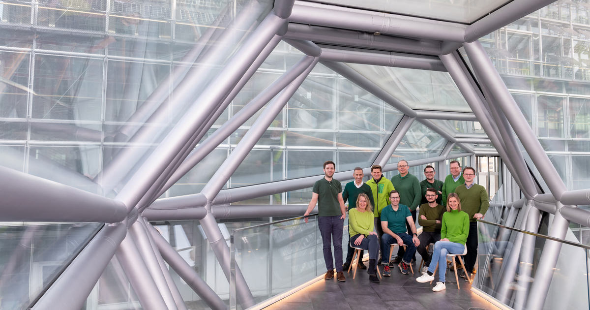 Teamfoto in einer modernen Glasbrücke für einen Geschäftsbericht.